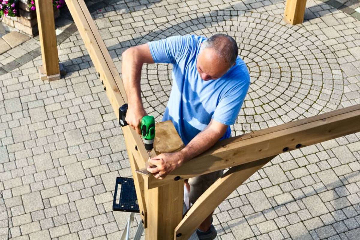 male contractor installing a new wooden pergolas in knoxville, Tn