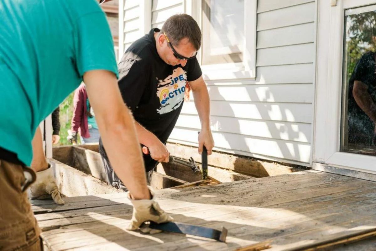 professional contractors repairing old deck