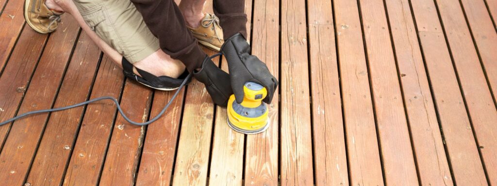 mature man performing maintenance on home wooden deck