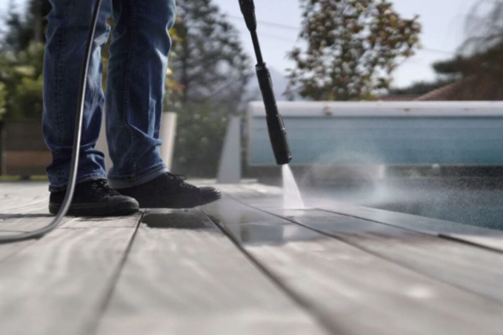 a man using water preasure on trex deck cleaning