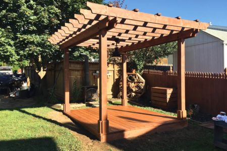 The newly built outdoor deck features a wooden pergola