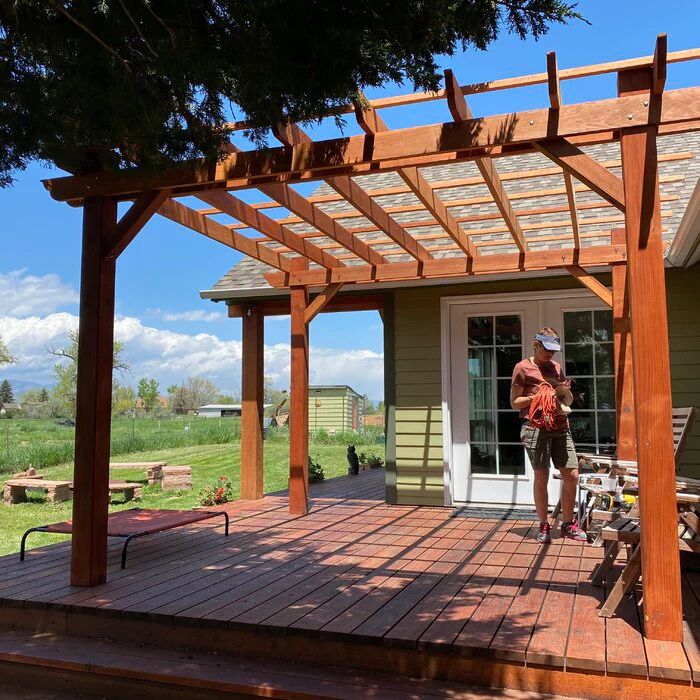 a male contractor adding pergola on deck